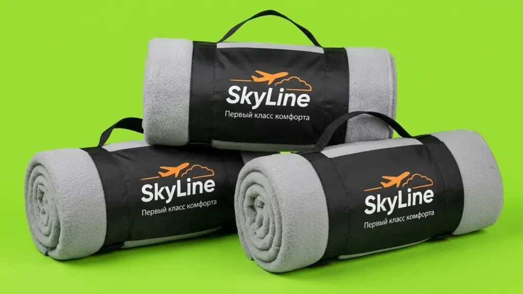 Три пледа SkyLine в чёрных чехлах-переносках, сложенные пирамидой на салатовом фоне