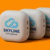 Три портативные колонки с логотипом SKYLINE Solutions под углом 45°, видны боковые разъёмы и петли