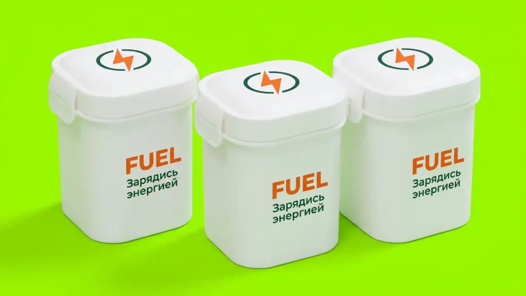 Три белых ланч-бокса FUEL в оранжево-зелёной графике на салатовом фоне, ракурс три четверти
